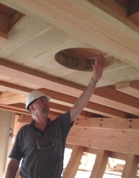 Standing below the topmost deck of the partially build Matthew Turner, Construction volunteer Ian Sidely shows the hole where the main mast will be inserted later in the project.